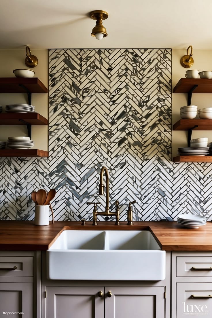 Kitchen with herringbone tile backsplash, farmhouse sink and brass faucet